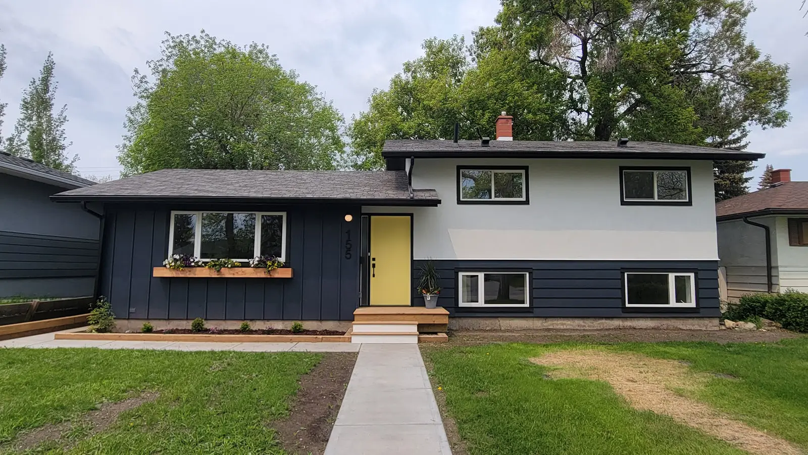 The same house exterior after new siding, windows and trim